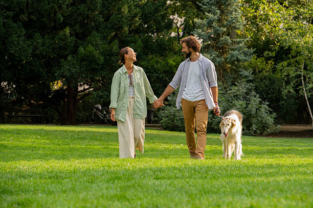 istock Couple walking with Borzoi dog in park on spring day 2234702707