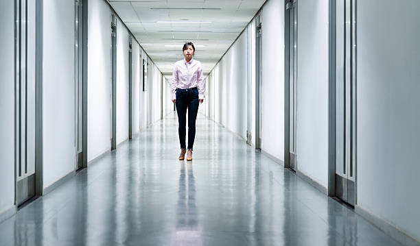 istock Front view of woman walking in a corridor 2234708475