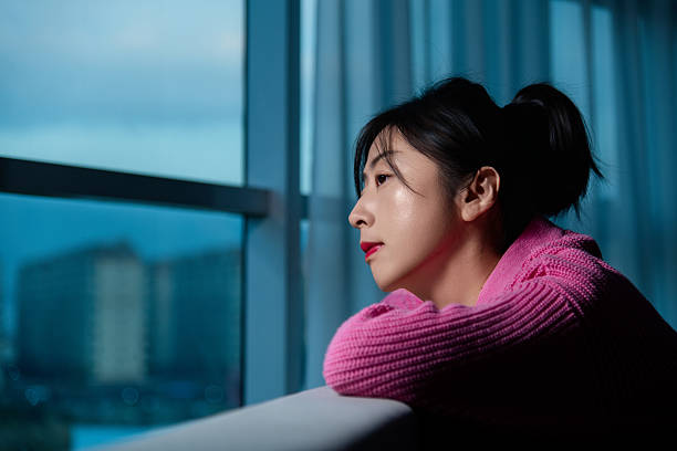 Woman leaning on the sofa and looking out the window