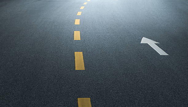 istock Yellow dashed line with arrow symbol on asphalt road 2234709383
