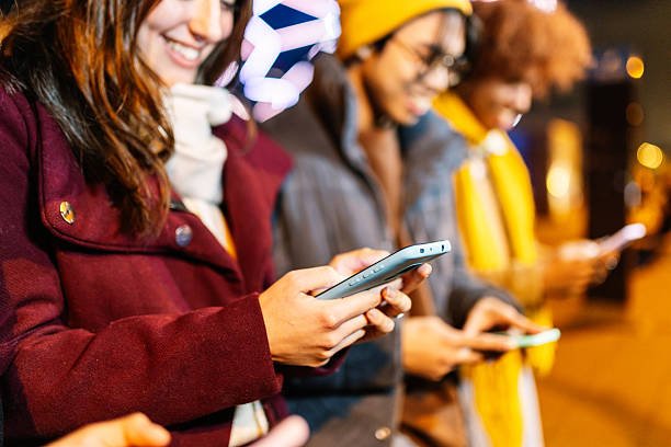 istock Happy millennial people using smart phones devices together outdoors on winter. 2234709629