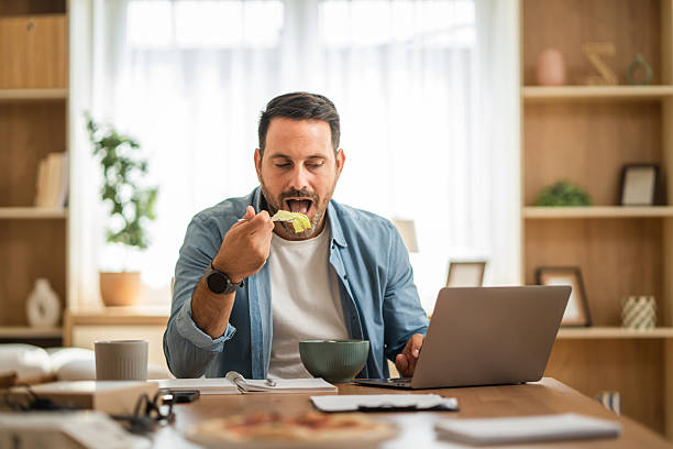 istock Freelancer eating salad and working on laptop at home 2234709992