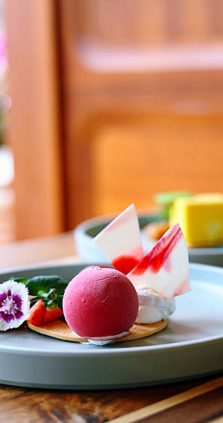 Gourmet dessert plate with vibrant cake, fresh fruit, edible flower,