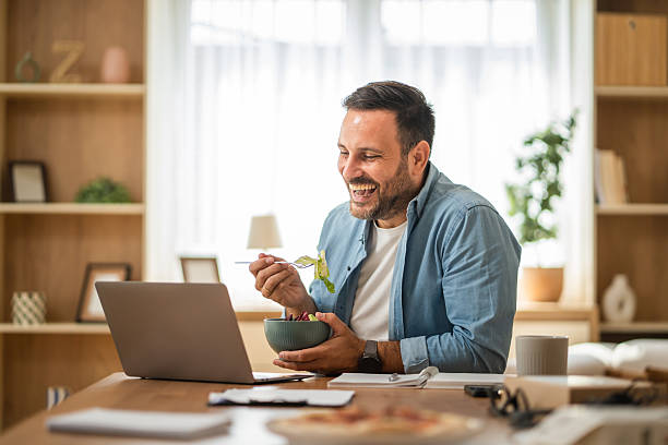 istock Happy entrepreneur enjoying healthy lunch while working remotely from home office 2234710438