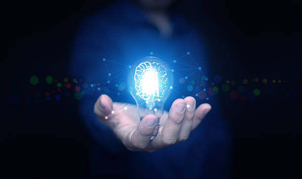 istock Hand holding glowing light bulb with brain and digital network lines symbolizing artificial intelligence, innovation, smart technology, knowledge, and futuristic business solutions. 2234710483