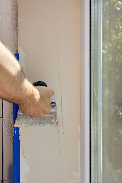 istock man with a spatula applying finishing putty on a window opening 2234710766