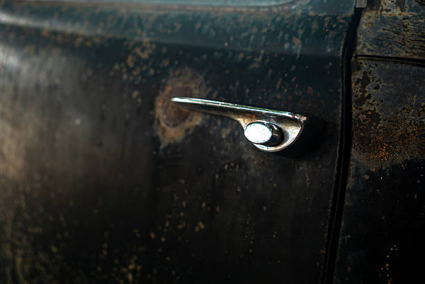 A close-up image of a vintage car door handle showcasing the beauty of rust and chrome. This detailed shot highlights the texture and history of an old vehicle.