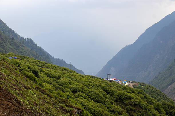 A breathtaking view of the Himalayan mountains covered in lush green forests along the trekking path to Kedarnath in Uttarakhand, India. The layered ridges and serene valley showcase the pristine beauty of the Garhwal Himalayas, offering a glimpse of the adventure and spirituality that define the Kedarnath pilgrimage journey. This natural landscape is ideal for themes of trekking, travel, spirituality, and eco-tourism.