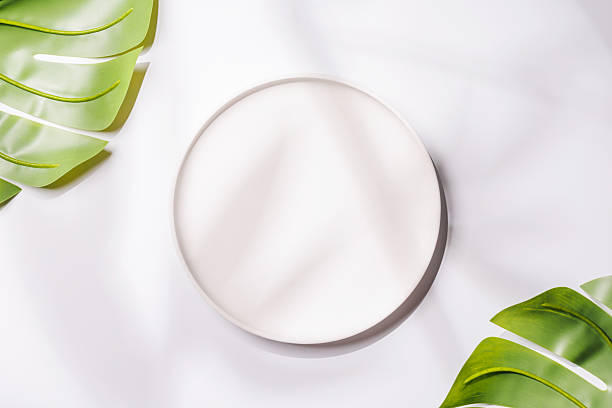 istock Empty plate on white background with leaves and shadows, food mockup with natural light 2234714247