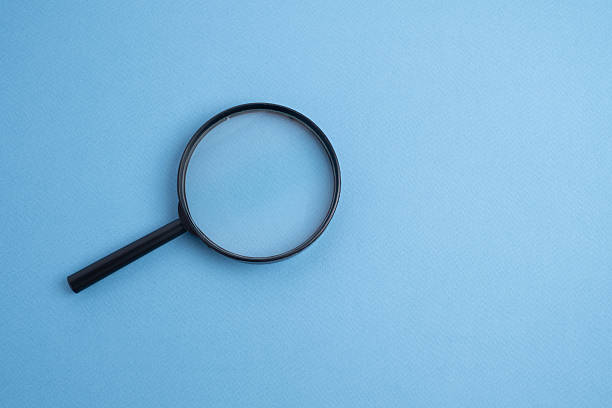 Magnifying glass on a colored background. Conceptual research, enlarging objects. Copy space for text.