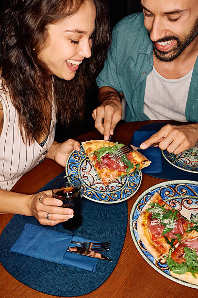 istock Happy couple eating pizza while having dinner in pizzeria. 2234718569