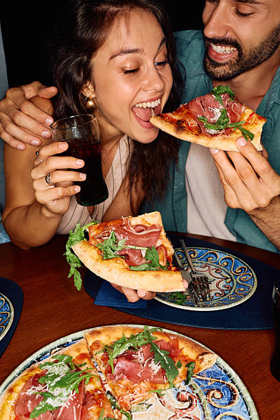 istock Carefree couple having fun while eating pizza. 2234718579