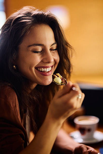 istock Young happy woman tasting a cake in a cafe. 2234718767