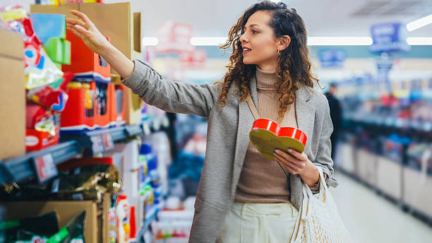 istock Woman comparing products while shopping at supermarket 2234724629