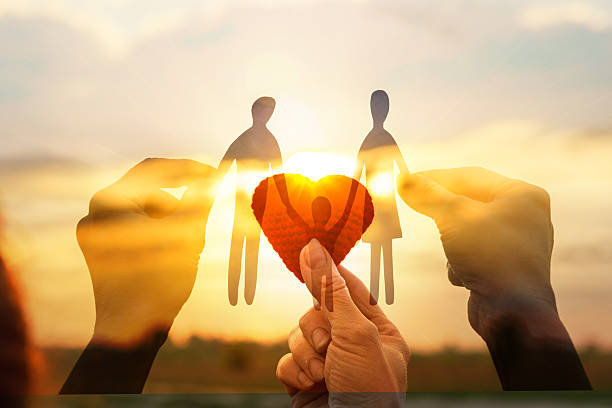 istock Hands holding paper figures with sunset background. 2234726656