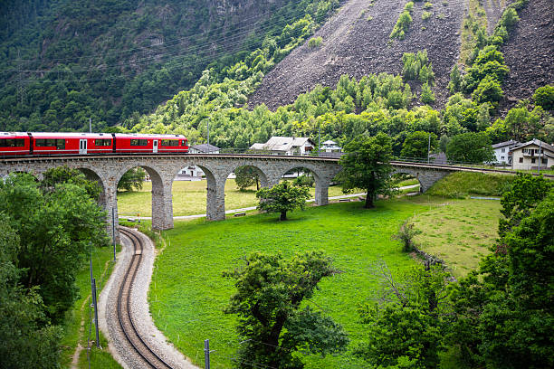 istock Red express train on a bridge in green Alps 2234729053