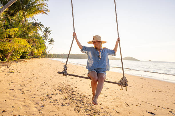 istock Woman Relaxing on Beach Swing at Sunset 2234730456