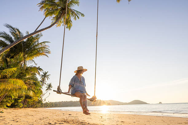 istock Woman Relaxing on Beach Swing at Sunset 2234730459