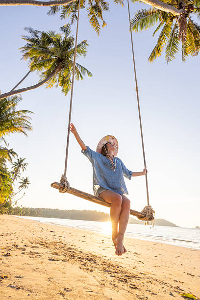 istock Woman Relaxing on Beach Swing at Sunset 2234730499