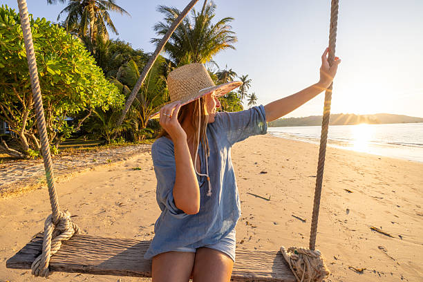 istock Woman Relaxing on Beach Swing at Sunset 2234730537