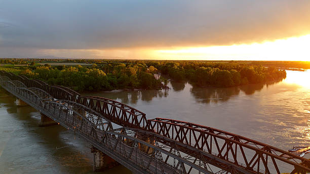 istock Aerial view of historic Iron Bridge crossing Po River during golden sunset, revealing architectural landmark amid verdant landscape in Cremona, Italy 2234731850