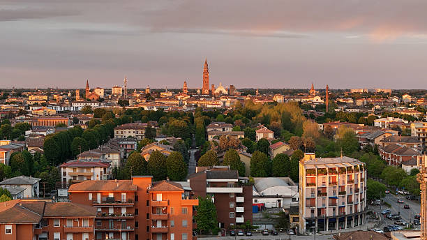 istock Cremona skyline revealing Torrazzo bell tower, cathedral silhouettes, residential zones, verdant landscapes under vibrant sunset lighting in Lombardy, Italy 2234731851