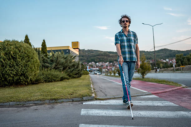 istock Blind Man Crossing Street With White Cane in Urban Setting 2234733261