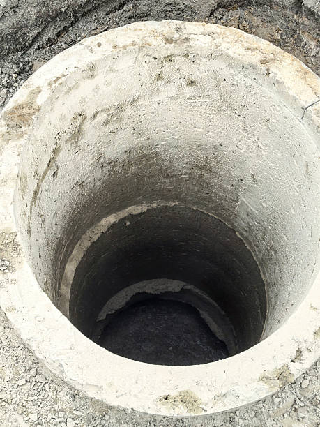 istock Septic sewer well made of concrete surrounded by rough terrain 2234735250
