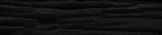 istock Dark black sand. Stripes and ripples of smooth volcanic sand texture or wallpaper. Wave pattern in black sand background. 2234740240