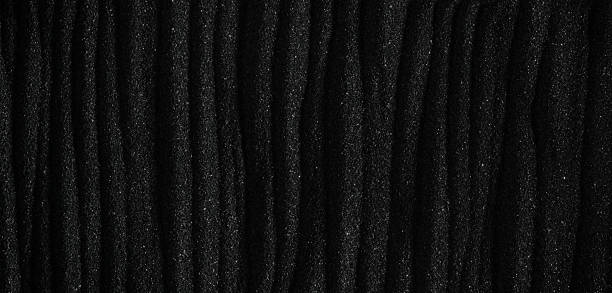 istock Dark black sand. Stripes and ripples of smooth volcanic sand texture or wallpaper. Wave pattern in black sand background. 2234740298