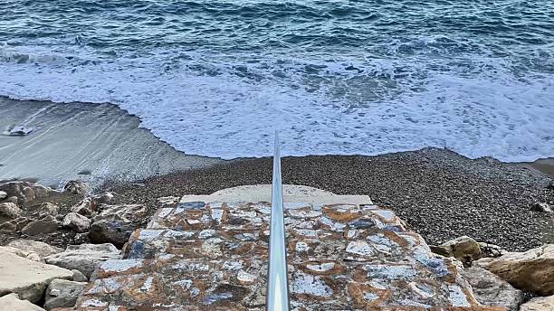 istock The scenic beach view features calm waves gently touching a rocky shore, creating tranquility 2234742065