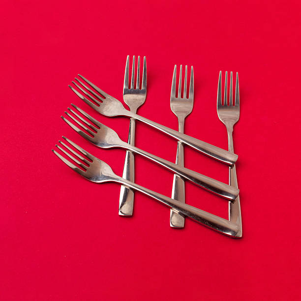 Metal forks creative layout on red background. Flat lay