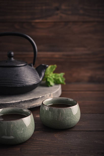 istock Cast iron black teapot and two bowls of tea 2234746301