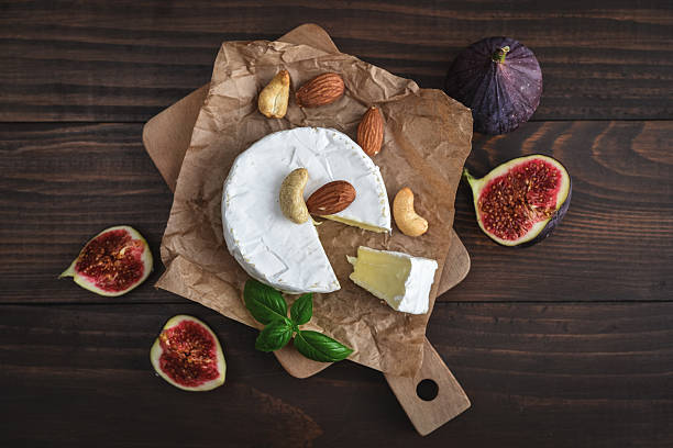 Camembert cheese with fresh figs on cutting board