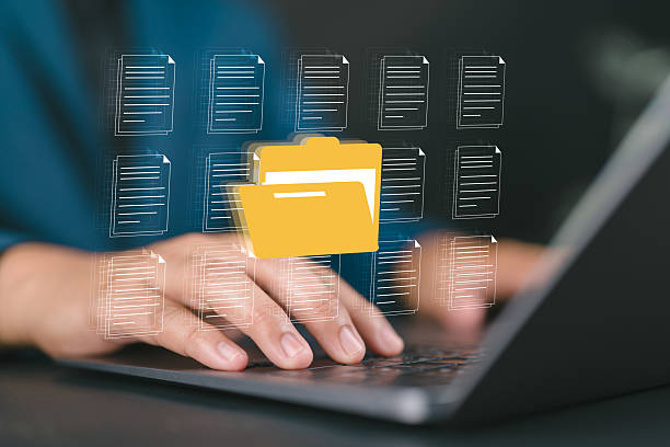 istock Businessman managing digital documents and folders on laptop with hologram interface, symbolizing data storage, cloud computing, file management, digital organization, and online information security 2234751587