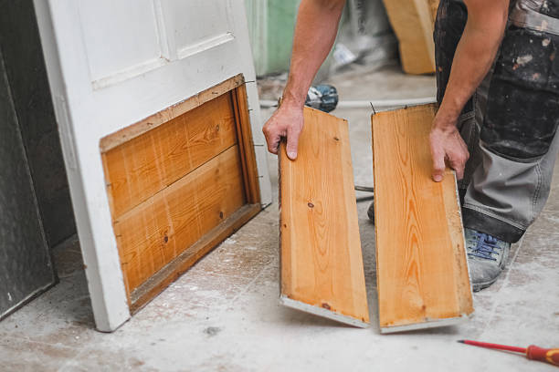 istock A young worker holds two small wooden boards from an old door. 2234752867