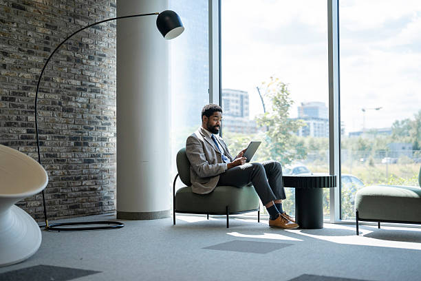 istock Businessman working on tablet in modern office lobby 2234756090