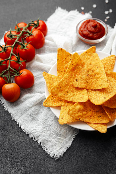 istock Nachos with fresh tomatoes, salsa and salt on white cloth over dark background 2234757183