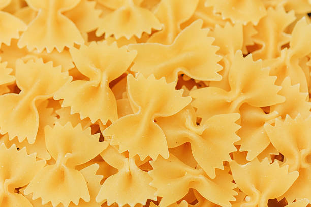 A collection of uncooked bowtie pasta pieces ready for a meal preparation.