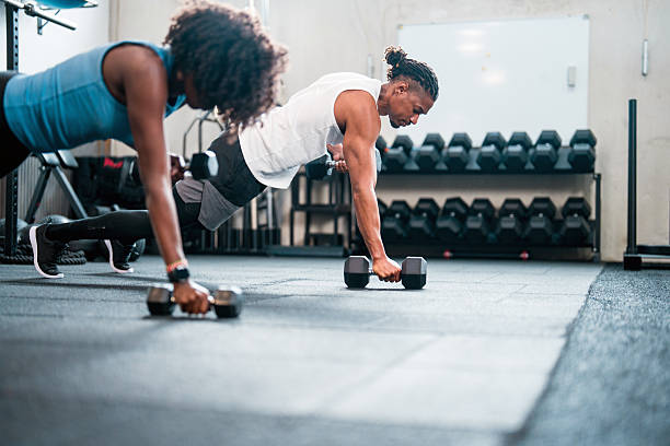istock Focused Black Couple Exercising with Dumbbells in Bright Gym Setting 2234758206