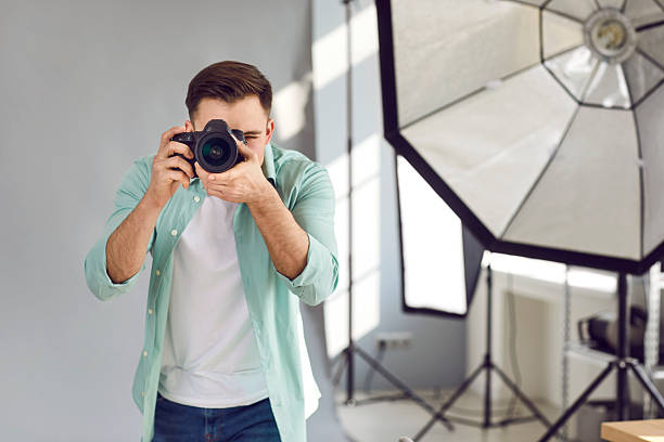 istock Young man photographer shooting with professional digital camera 2234758471