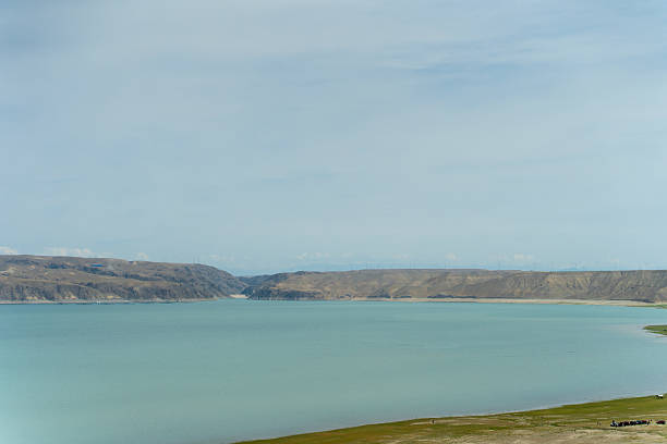 The freshwater lake, the azure sky and the wheat fields beneath the continuous mountain range