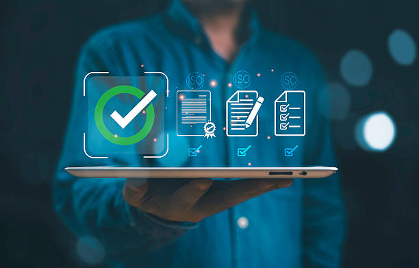 istock Businessman holding tablet with digital ISO certification icons quality assurance compliance management, document approval standardization data security, and business process control. 2234773694