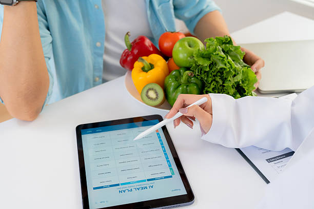 istock Asian nutritionist using tablet to explaining personalized meal plan with AI to patient during healthcare consultation, healthy lifestyle, woman dietitian showing nutrition plan with AI on tablet. 2234780204