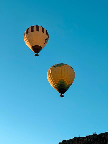 istock Hot Air Balloons Floating in Clear Blue Sky 2234783200