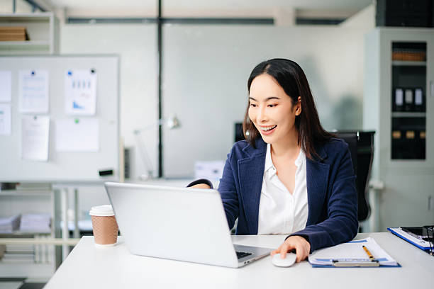 istock Confident Asian businesswoman working in modern office, using laptop and tablet, planning strategy at desk 2234786784