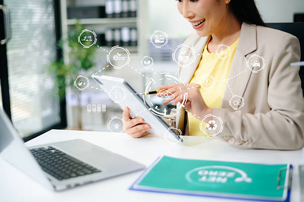 istock Asian woman using tablet with futuristic eco interface showing CO2, battery, wind, and recycle icons. Concept of smart sustainability, net zero tech, and green innovation. 2234786845