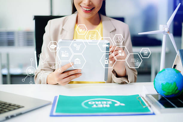 istock Asian woman using tablet with futuristic eco interface showing CO2, battery, wind, and recycle icons. Concept of smart sustainability, net zero tech, and green innovation. 2234786858