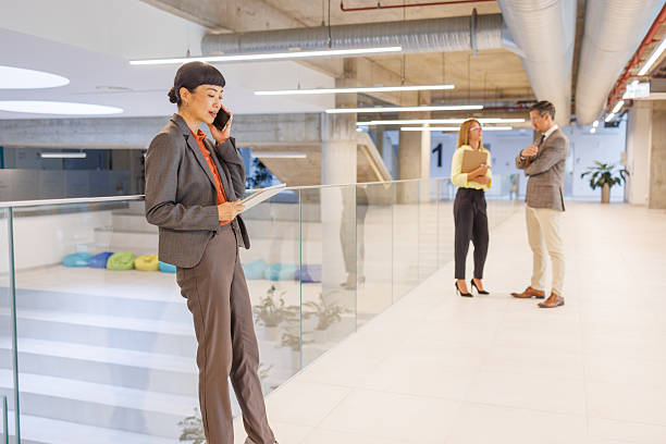istock Businesswoman talking on phone and holding documents in modern office 2234791844