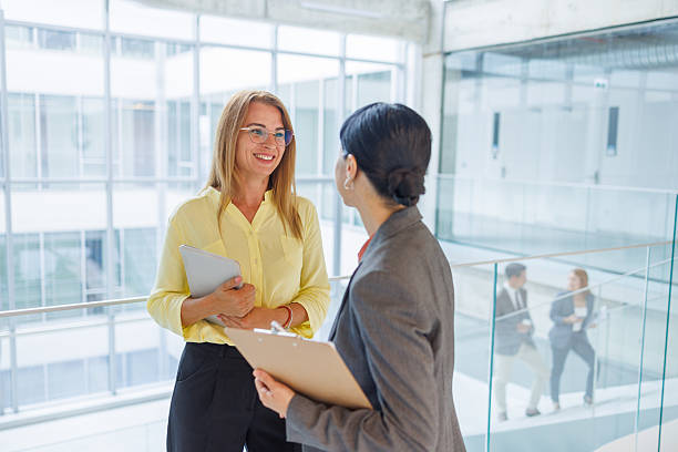 istock Two businesswomen talking and smiling in modern office 2234792115